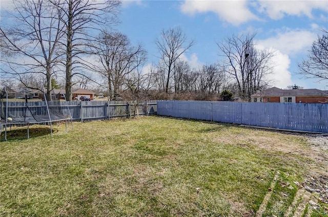 view of yard featuring a trampoline and a fenced backyard