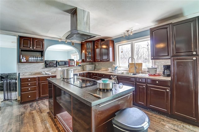 kitchen with tasteful backsplash, a sink, black electric stovetop, island exhaust hood, and dark wood-style flooring