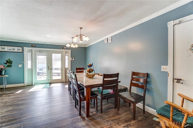 dining space featuring crown molding, baseboards, dark wood finished floors, french doors, and an inviting chandelier