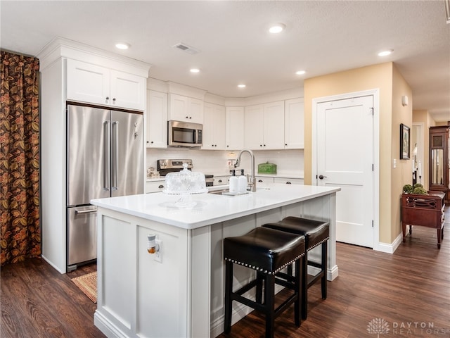 kitchen featuring visible vents, appliances with stainless steel finishes, dark wood finished floors, and white cabinetry