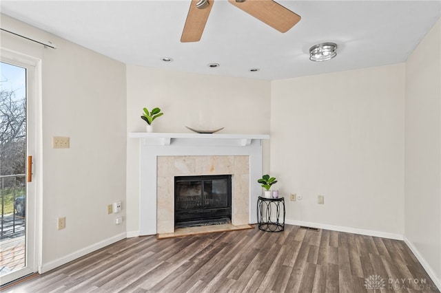 unfurnished living room with wood finished floors, a ceiling fan, visible vents, and baseboards