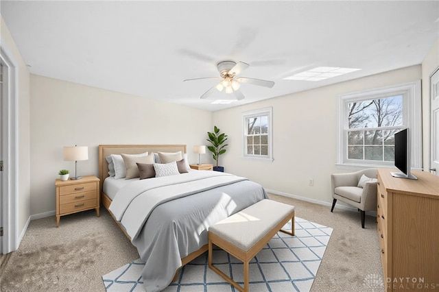 bedroom featuring light colored carpet, a ceiling fan, and baseboards