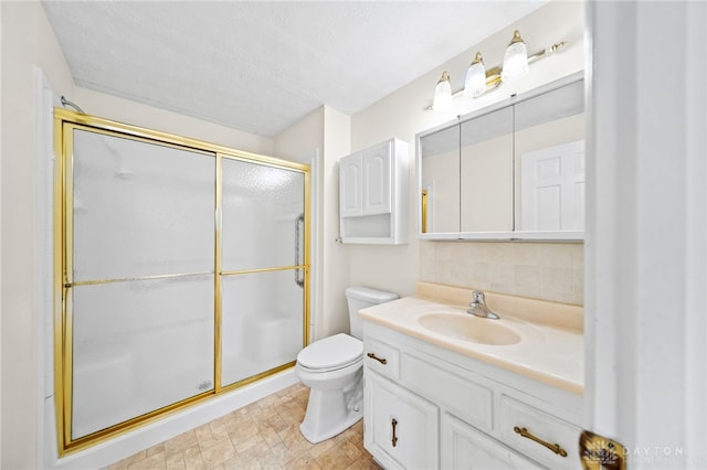 bathroom with toilet, a stall shower, tasteful backsplash, a textured ceiling, and vanity