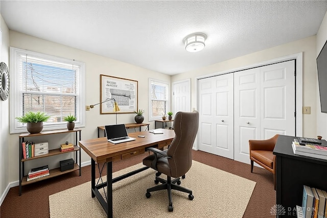 office area featuring dark carpet, a textured ceiling, and baseboards