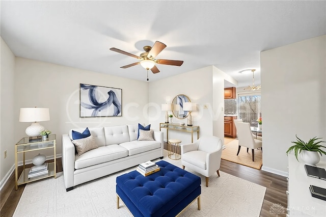 living area featuring baseboards, a ceiling fan, and wood finished floors