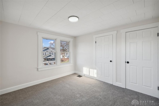 unfurnished bedroom featuring carpet flooring and baseboards