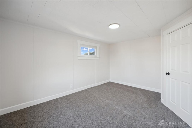 carpeted empty room featuring baseboards