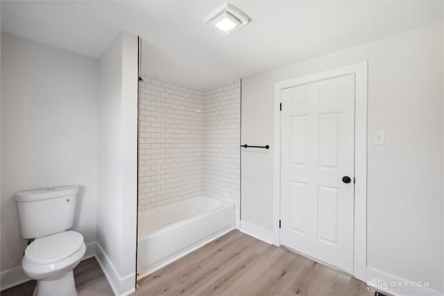 bathroom with toilet, shower / bath combination, baseboards, and wood finished floors