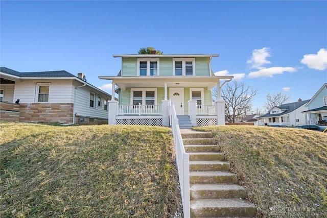 american foursquare style home featuring a porch and stairs