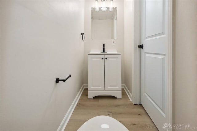 bathroom featuring baseboards, wood finished floors, and vanity