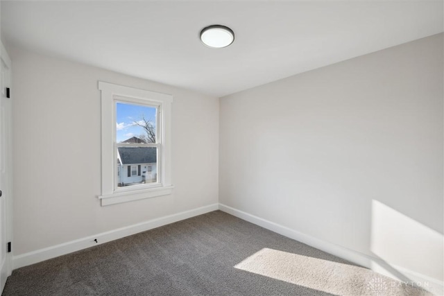 carpeted spare room featuring baseboards