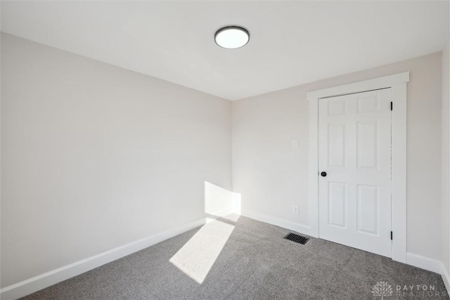 empty room featuring baseboards and carpet