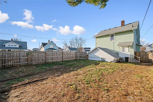 view of yard with a fenced backyard and entry steps