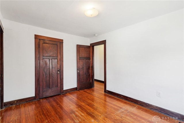 unfurnished bedroom featuring dark wood finished floors and baseboards