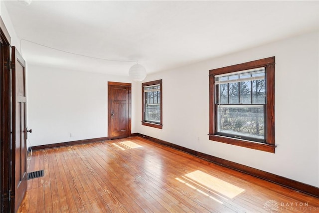 unfurnished room featuring visible vents, baseboards, and light wood-style floors