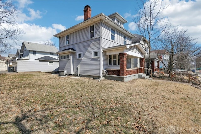 back of property featuring a lawn, central AC, and a chimney