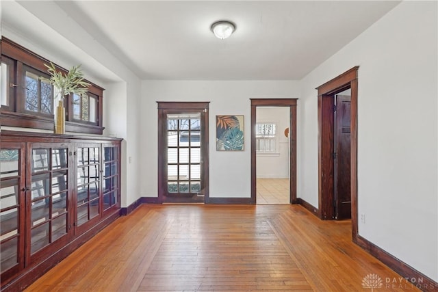 unfurnished room featuring baseboards and hardwood / wood-style flooring