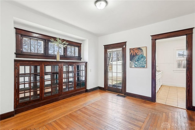 spare room with visible vents, baseboards, and hardwood / wood-style floors