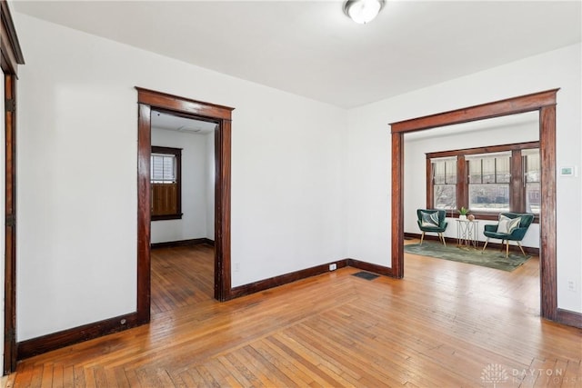 spare room featuring visible vents, baseboards, and light wood-type flooring