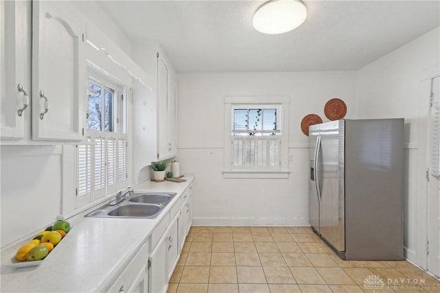 kitchen featuring stainless steel fridge, light countertops, a healthy amount of sunlight, and a sink