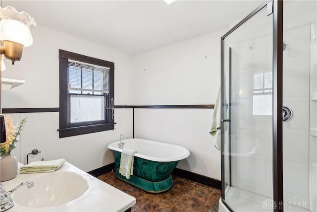 full bath featuring a freestanding tub, a stall shower, and wainscoting