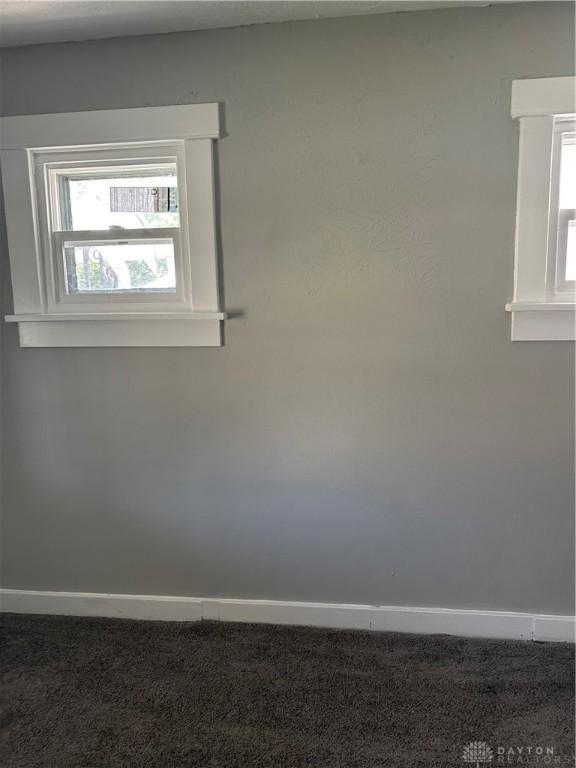 carpeted spare room featuring baseboards