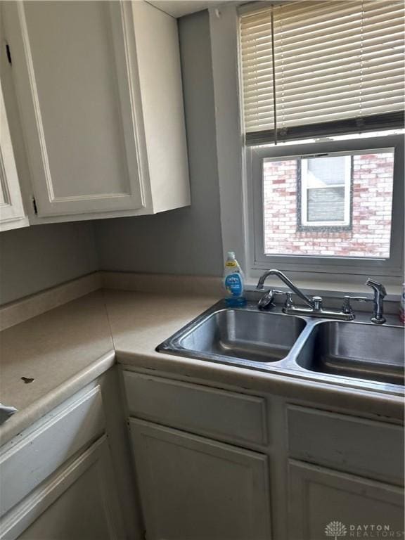 kitchen with white cabinetry and a sink