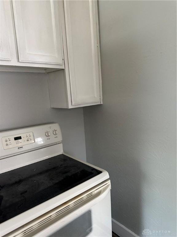 kitchen featuring white cabinetry and electric range