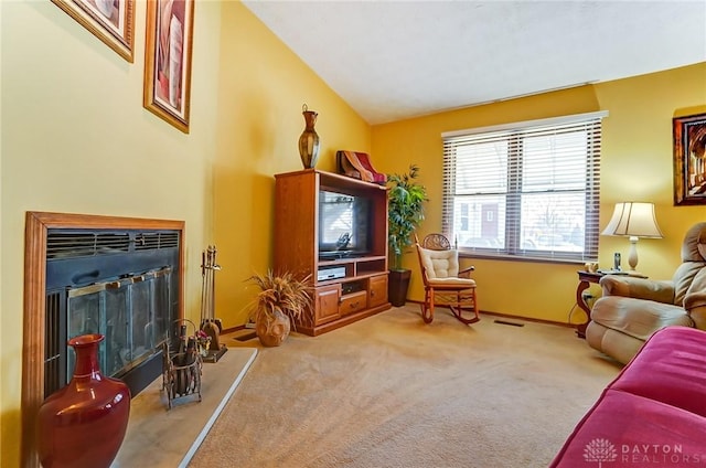 living area featuring visible vents, baseboards, lofted ceiling, light carpet, and a fireplace