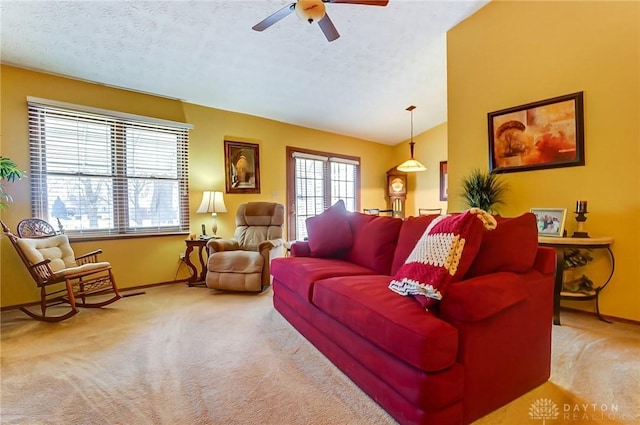 living room featuring lofted ceiling, carpet, a ceiling fan, and a textured ceiling