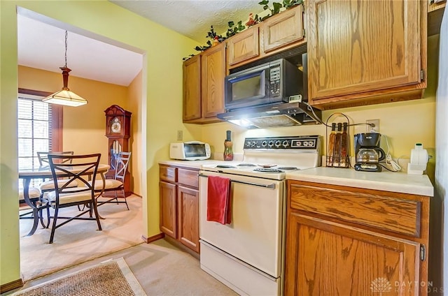 kitchen featuring black microwave, decorative light fixtures, light colored carpet, light countertops, and electric range