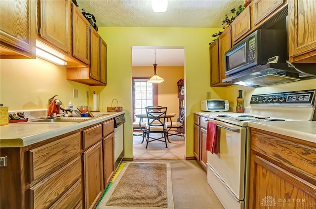 kitchen with white appliances, brown cabinetry, and light countertops