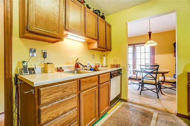 kitchen featuring brown cabinetry, dishwasher, a textured ceiling, and light countertops