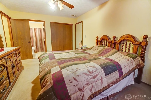 bedroom with a closet, ensuite bath, carpet, and a ceiling fan