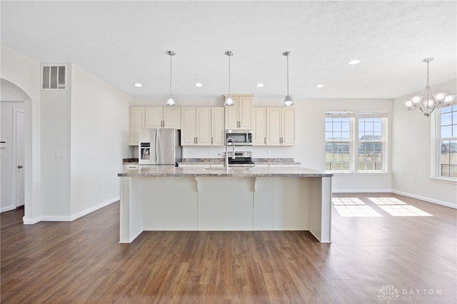 kitchen with stainless steel appliances, arched walkways, visible vents, and dark wood-style floors