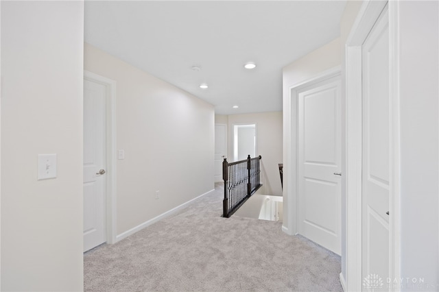 hall featuring an upstairs landing, carpet flooring, recessed lighting, and baseboards