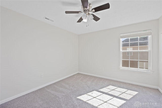 carpeted empty room with a ceiling fan, baseboards, and visible vents