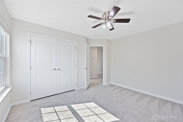 unfurnished bedroom with carpet, baseboards, a closet, and ceiling fan