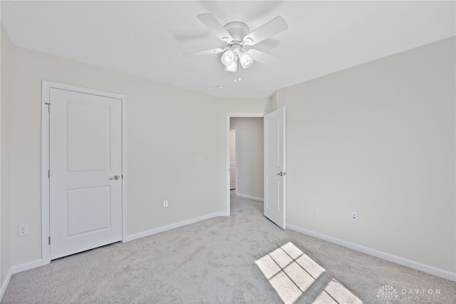 unfurnished bedroom featuring baseboards, light colored carpet, and ceiling fan