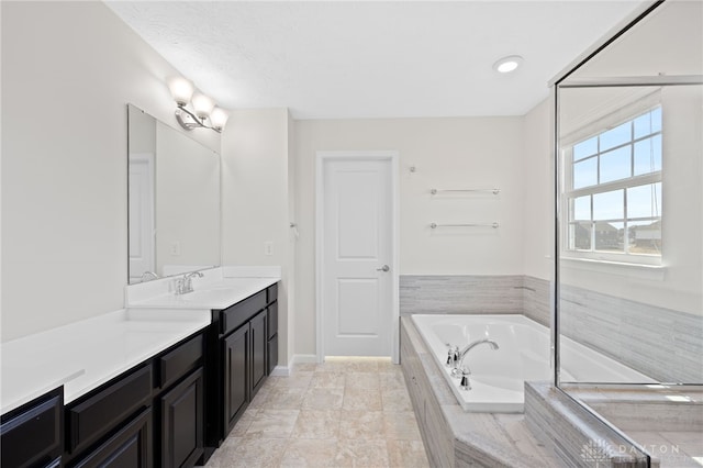 bathroom with vanity and a garden tub