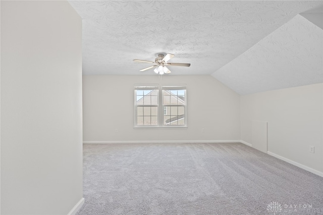 bonus room featuring a ceiling fan, a textured ceiling, carpet, baseboards, and vaulted ceiling