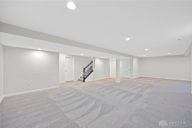 finished below grade area featuring stairs, recessed lighting, light colored carpet, and baseboards