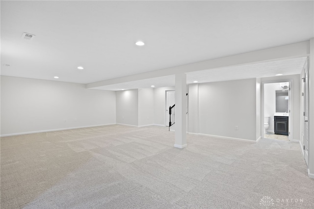 finished basement with light carpet, visible vents, recessed lighting, and baseboards