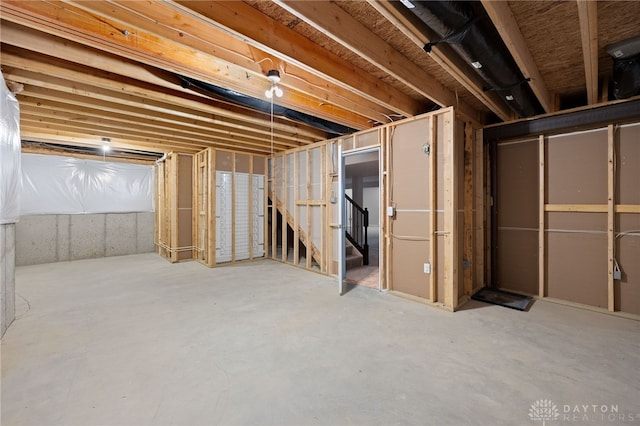 unfinished basement featuring stairs