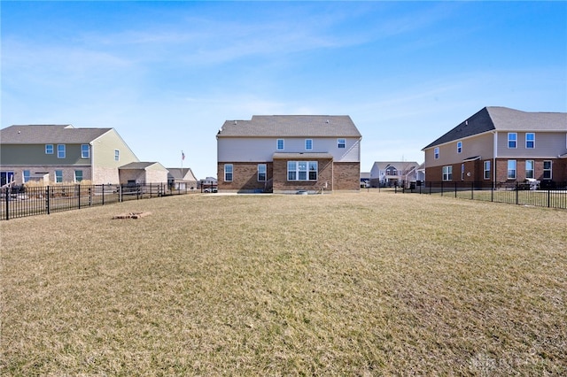 back of house featuring a yard, a residential view, and fence