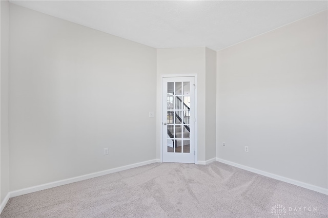 empty room featuring baseboards and carpet floors