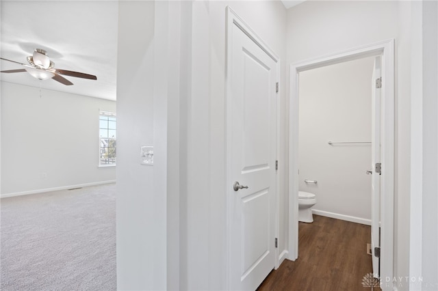 corridor featuring baseboards and carpet