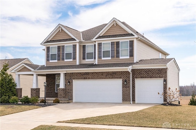 craftsman-style home featuring a front yard, roof with shingles, covered porch, concrete driveway, and brick siding