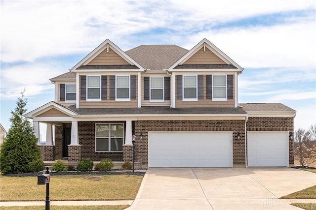 craftsman-style home with a front yard, brick siding, driveway, and roof with shingles