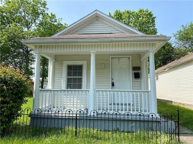 view of front of home with covered porch and a fenced front yard